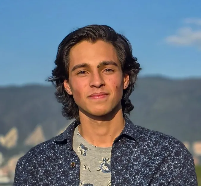 Sebastián Villota smiling, with the Bogotá hills behind him